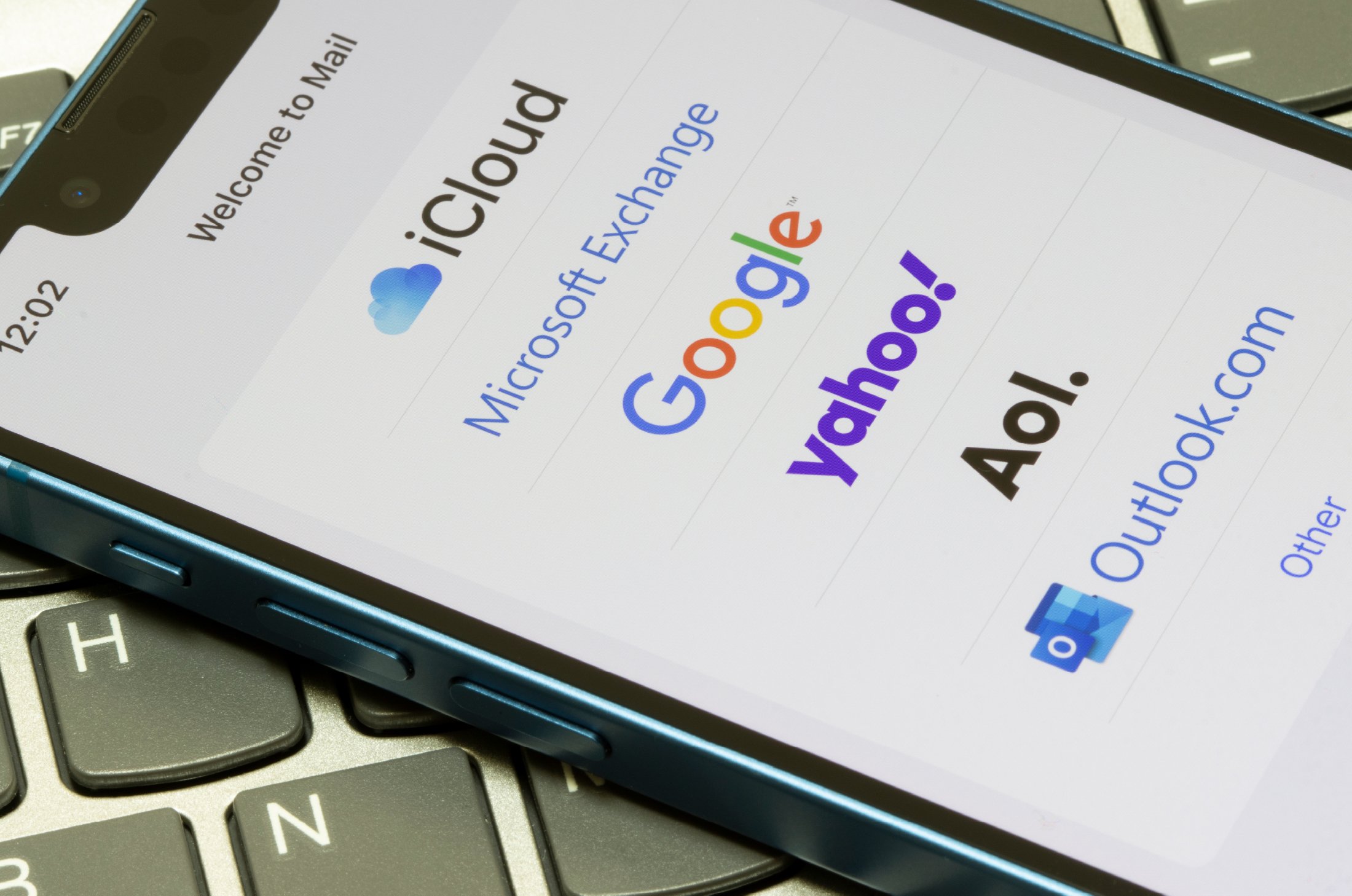 A phone with a list of email providers' logos