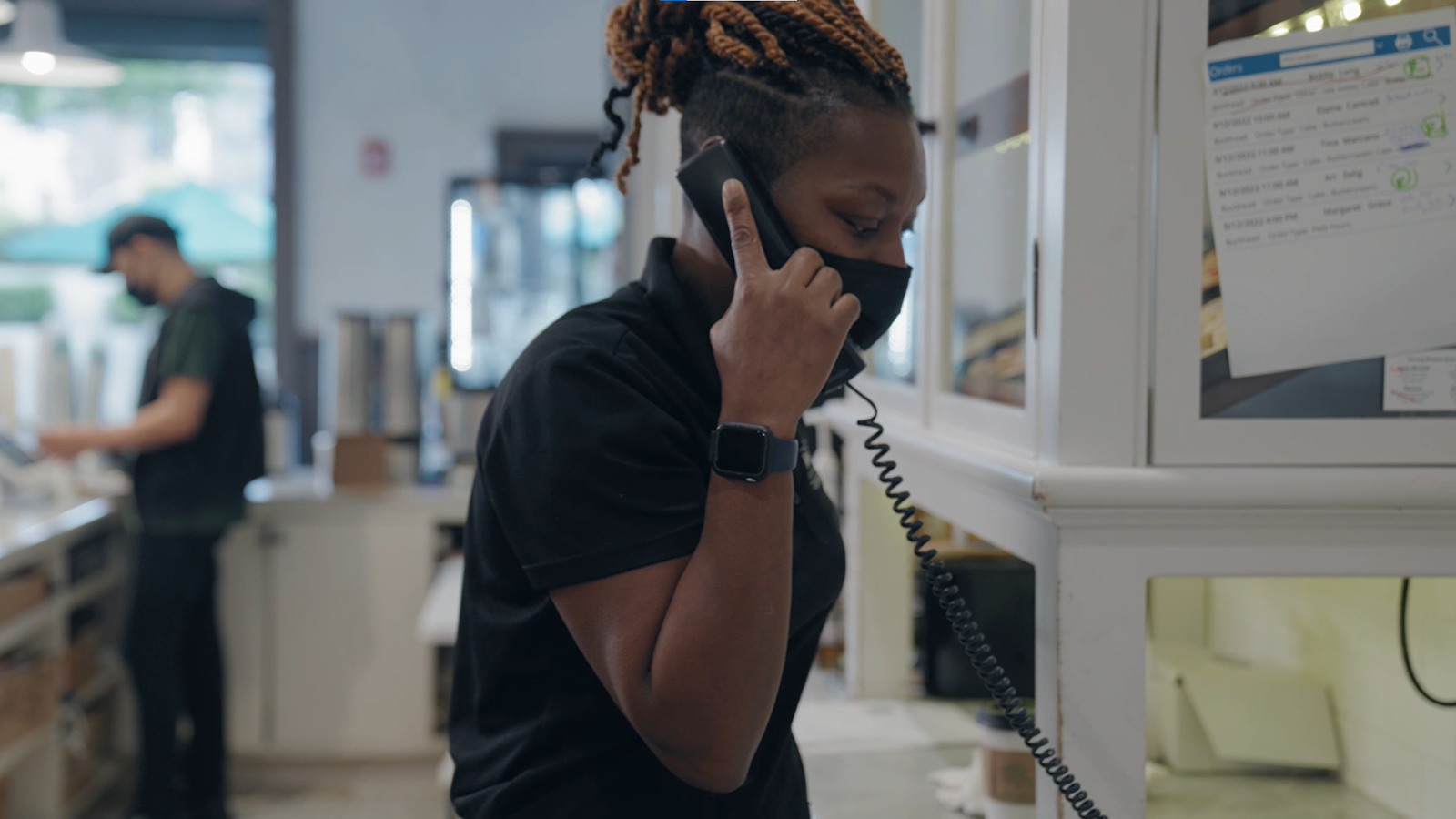 Restaurant employee answering the phone at the counter