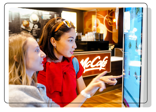 Customers ordering at a McDonald’s self-service kiosk