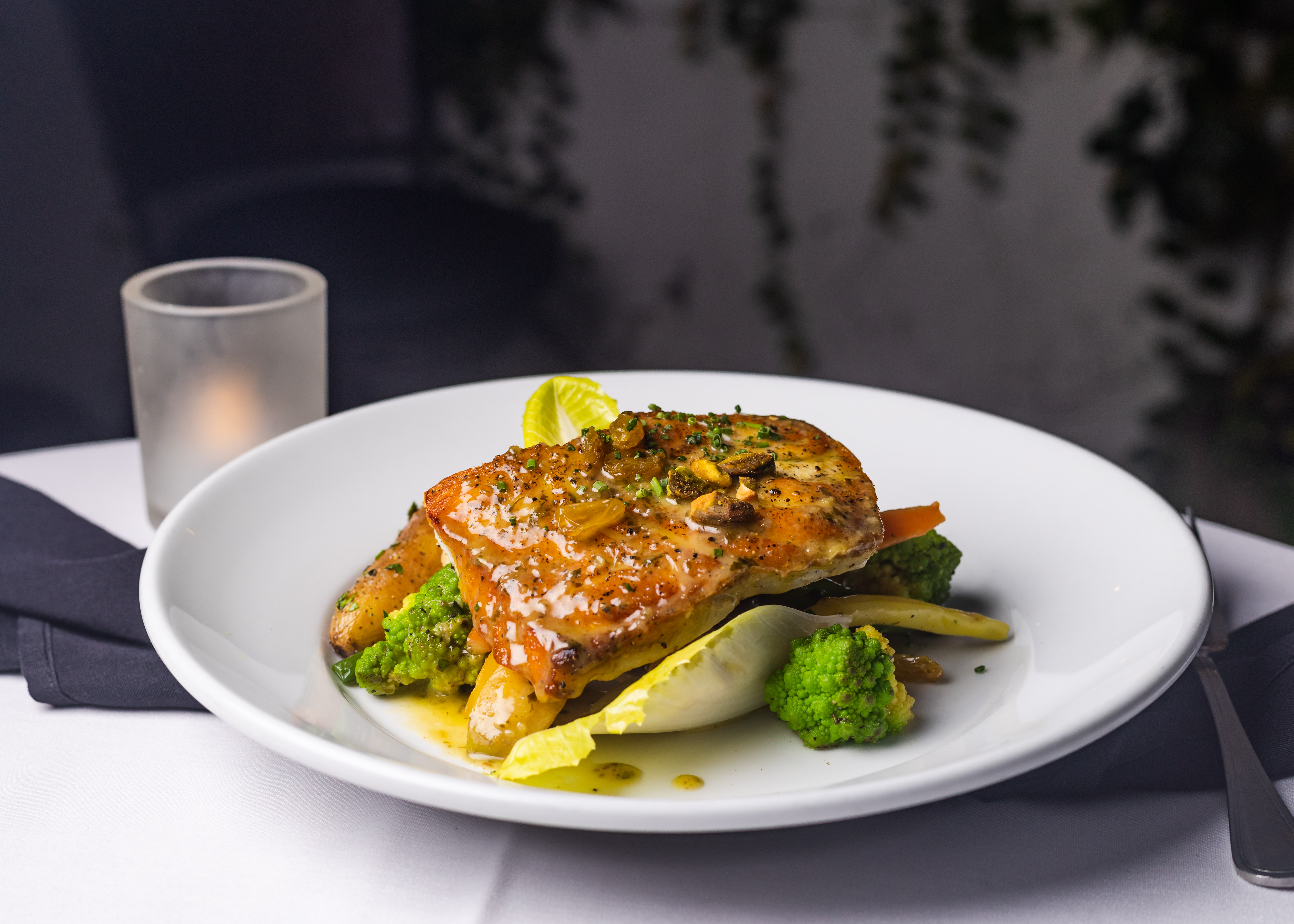 Plated fish with pistachios shot in soft natural light