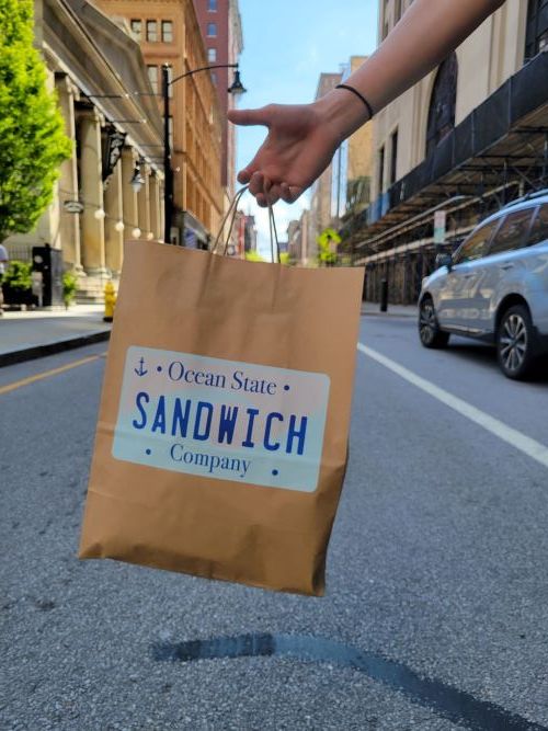 Ocean State Sandwich Company delivery bag held on a city street
