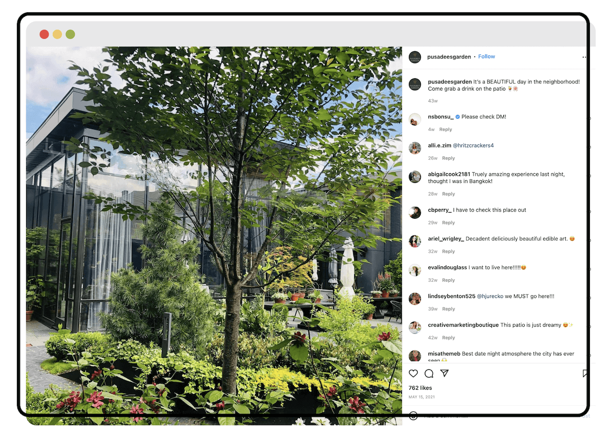 A lush garden patio with a large tree and flowering plants, shared on social media to promote the space