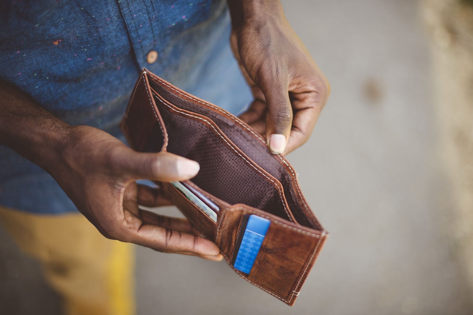 Man holding open an empty leather wallet