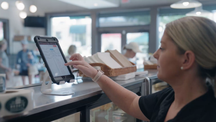 Restaurant employee taking an order on a tablet POS at the counter