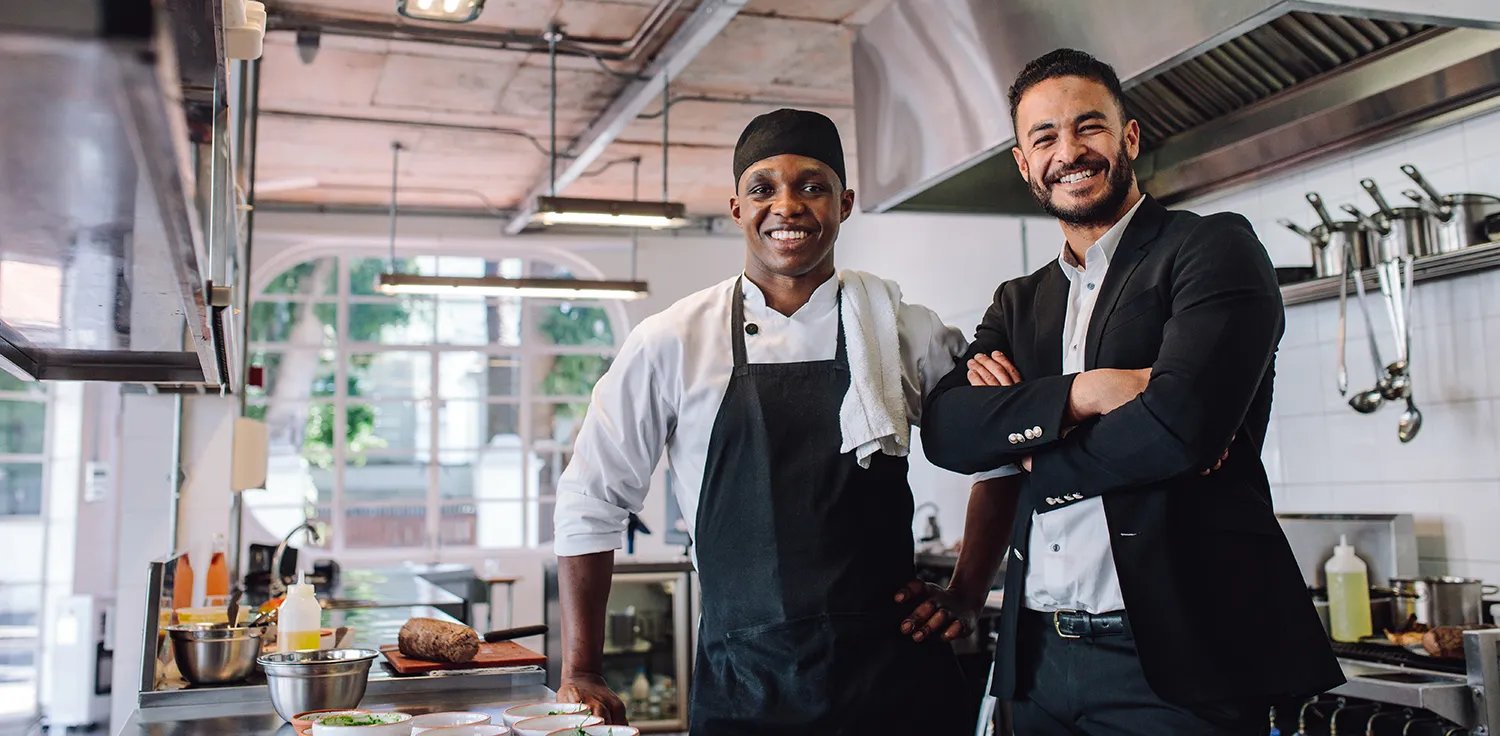 Restaurant chef and owner standing together in the kitchen