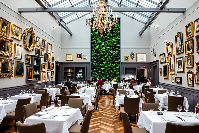 An upscale restaurant dining room with ornate decor and a living plant wall