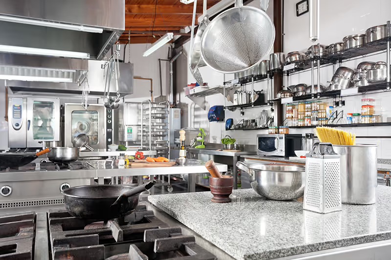 A commercial restaurant kitchen with stainless steel cooking equipment