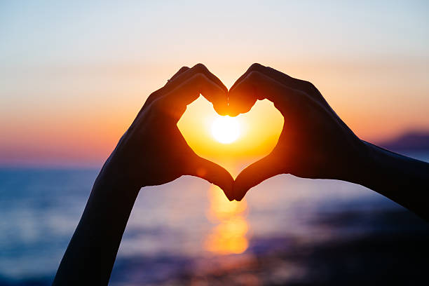 Hands forming a heart at sunset, promoting the Valentine's Dinner ordering event