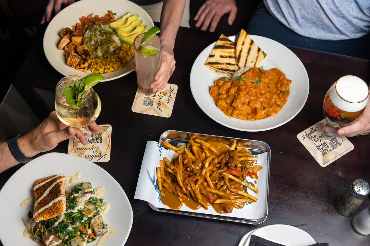 Overhead view of shared plates and cocktails on a table at Fadó Irish Pub